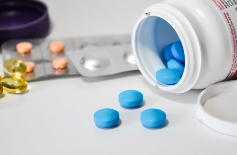 Pills spilling out of a container Traditional ED Medications