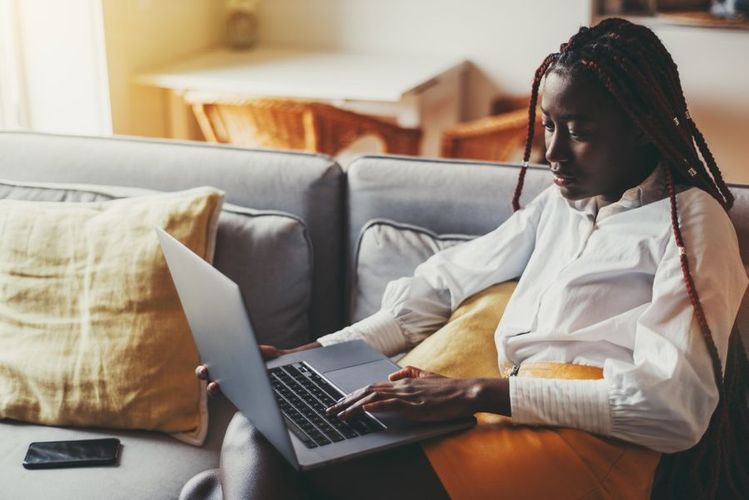 a-portrait-of-a-cute-young-black-woman-with-braids-at-home-sitting-on-the-sofa-in-the-living-room_t20_R0OxbQ.jpeg