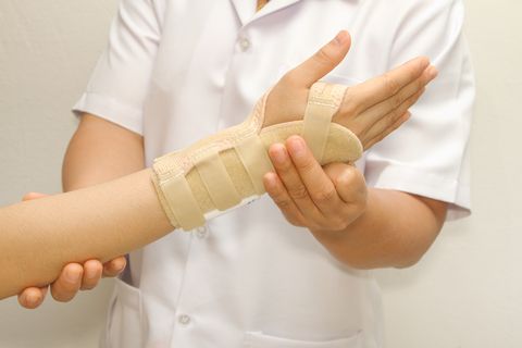 pharmacist putting on wrist brace