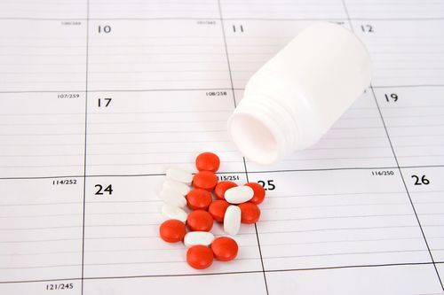Medication spilled onto a calendar Medication Synchronization
