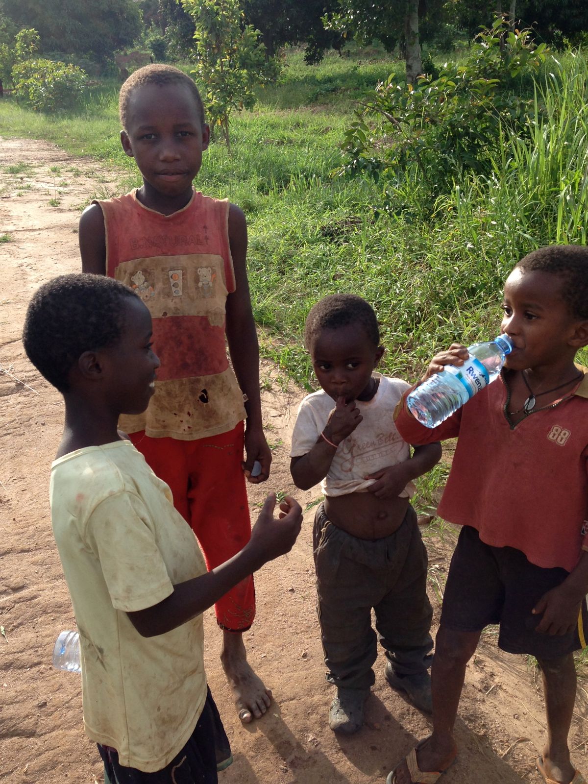 Sharing a clean bottle of water with our younger friends in Bweya, where a bore hole/ well is desperately needed