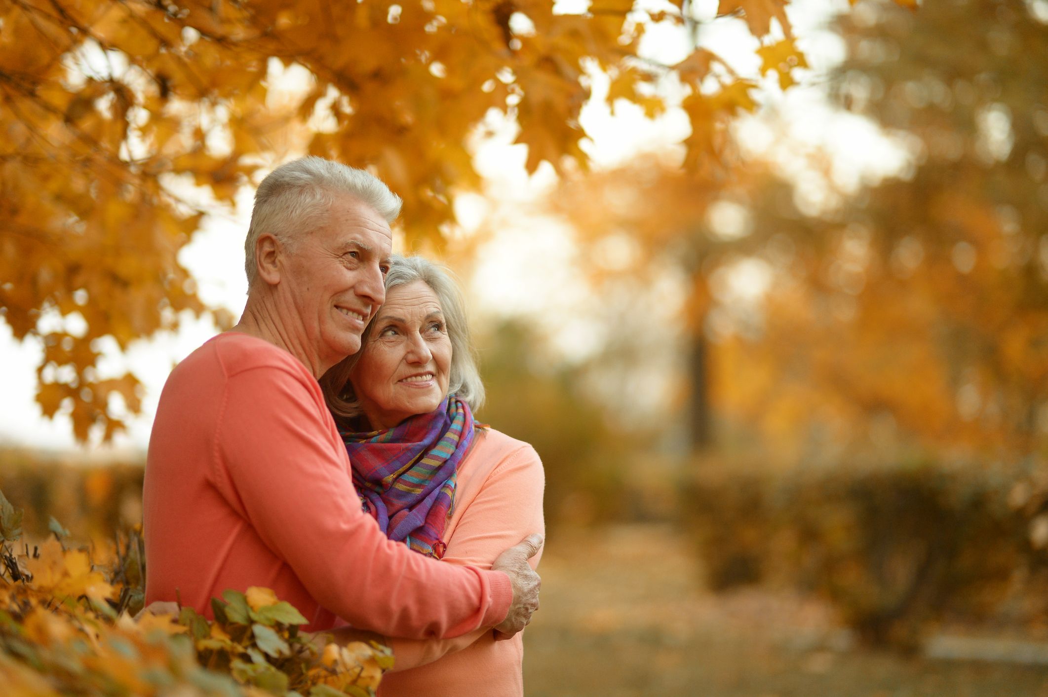 Elderly couple hugging outside during fall Medicare Open Enrollment