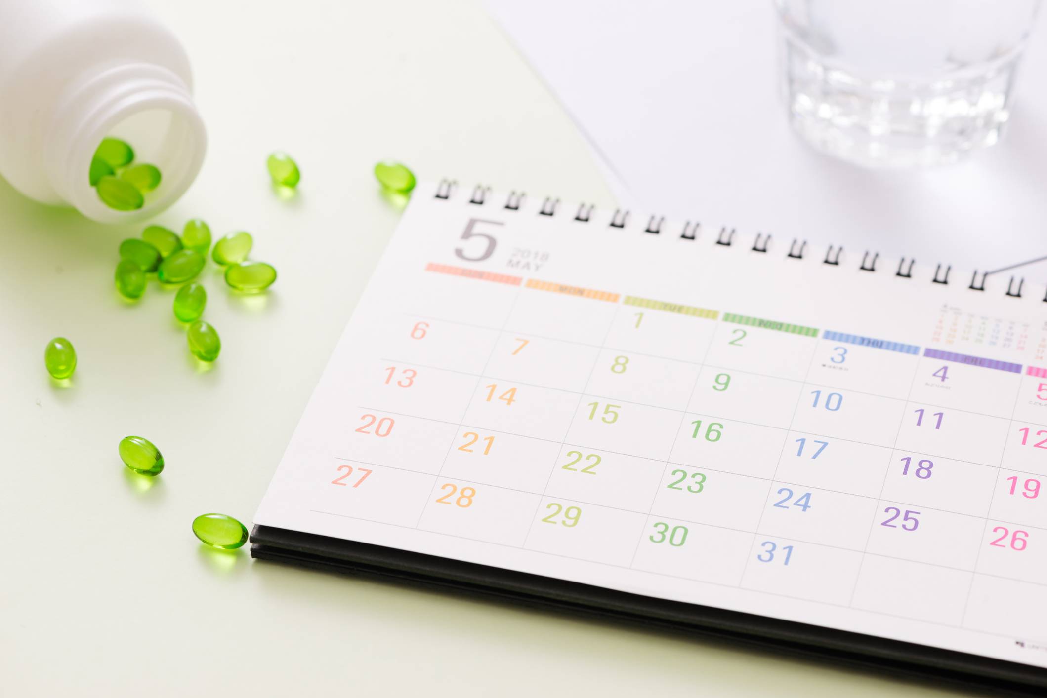 Image of a colorful calendar with a bottle of green pills spilled on it Scheduled Appointments
