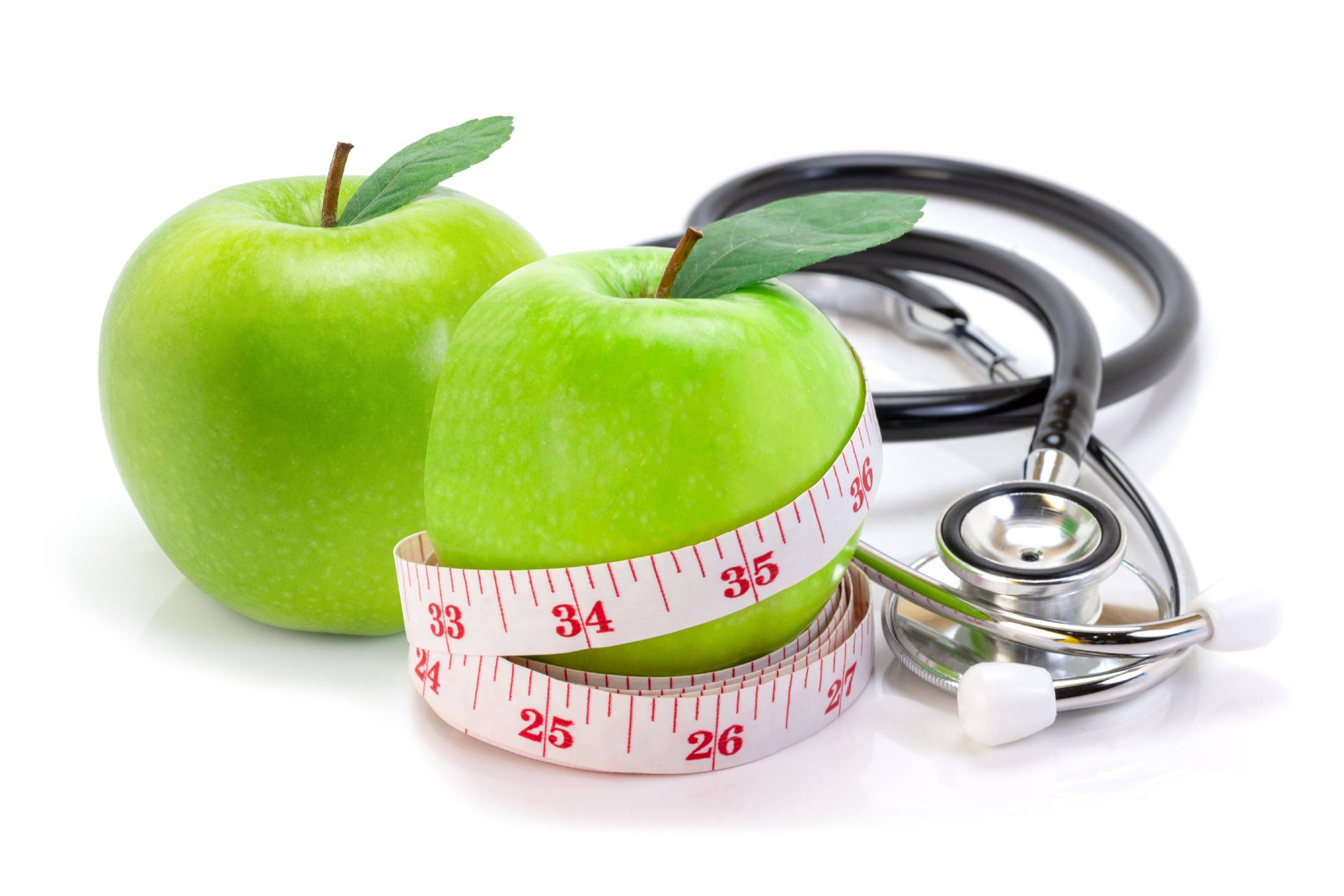 Image of two green apples that are wrapped with a measuring tape and stethoscope Vitamins and supplements