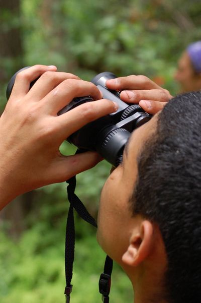 Boy with binoculars at El Ranchito Nature Discovery Camp, Austin