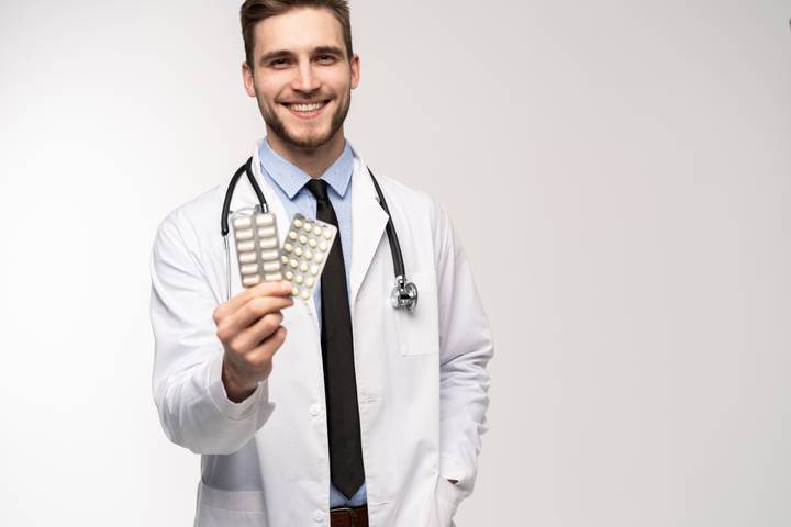 Male pharmacist holding pills Pharmacist with pills