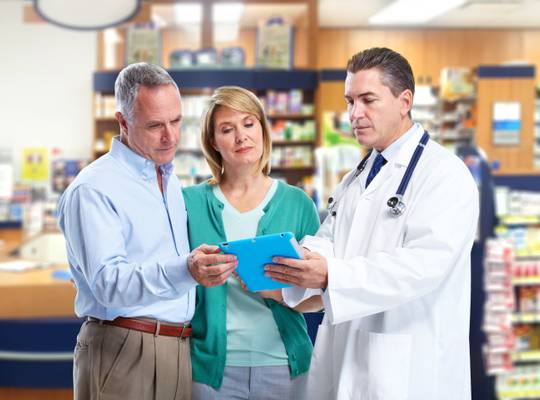 Pharmacist talking to two adults Peace Pharmacy