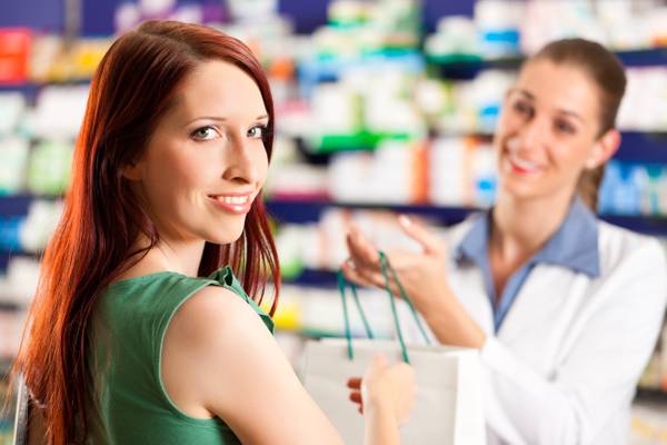 Pharmacist handing a bag to a patient Peace Pharmacy