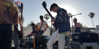 A guitarist playing an electric guitar at an outdoor concert