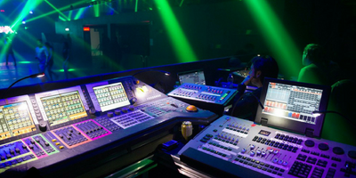 An image of lighting techs sitting at a lighting controller at an event