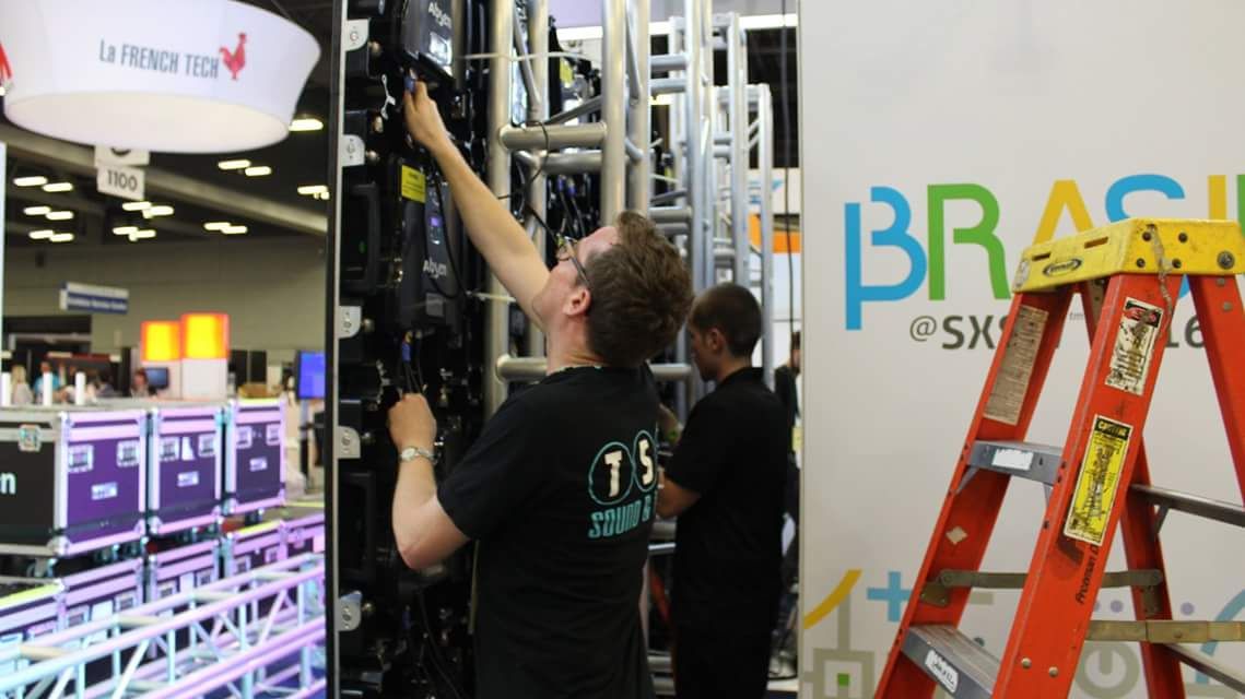 An image of Michael Greig setting up and LED video wall at a trade show in Los Angeles 