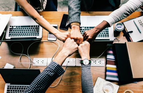 An image of an event team fist bumping