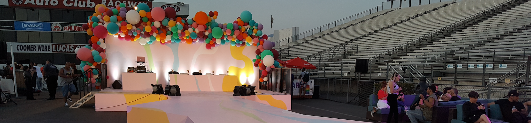 An outdoor stage design from an LGBTQ+ event with colorful balloons and splatter paint