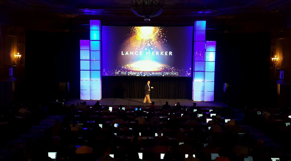 A speaker on stage at a large conference