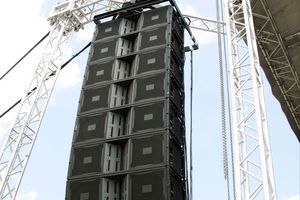 An image of a large JBL speaker rigged to a truss at an outdoor event