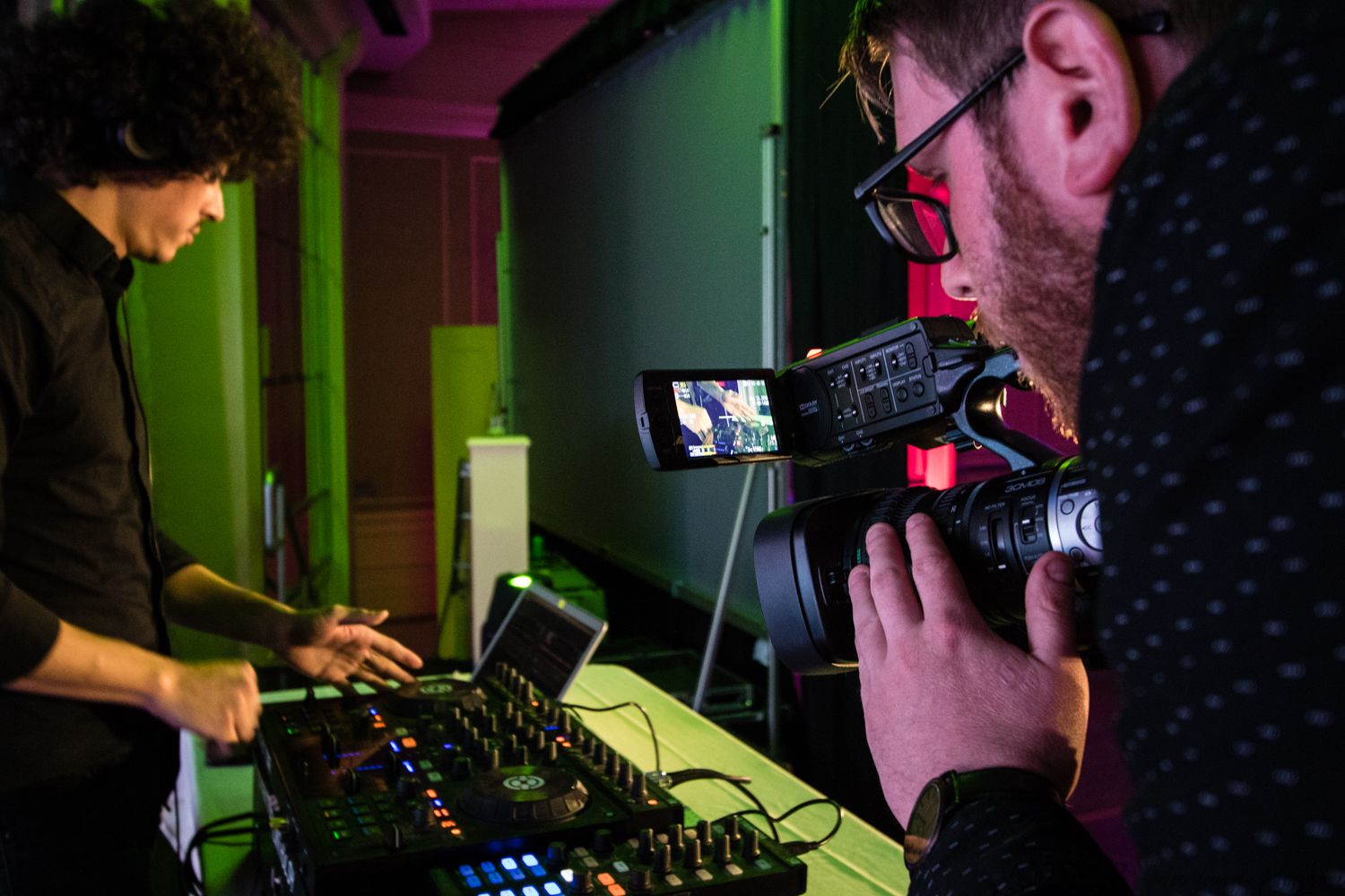 A videographer getting a close-up of a DJ at a nonprofit gala 