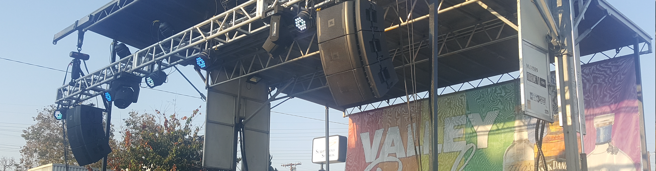 JBL speakers rigged to a truss at an outdoor concert