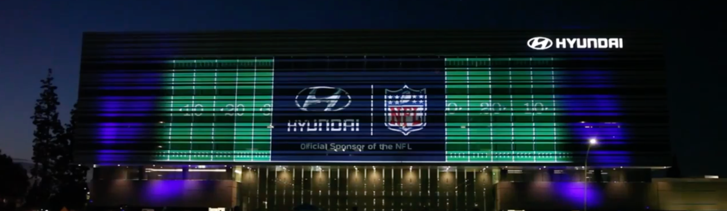 A large NFL video projection display on the side of the Hyundai headquarters 