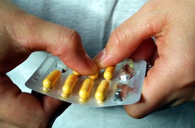 Image of a person getting medication from blister pack Medication Services