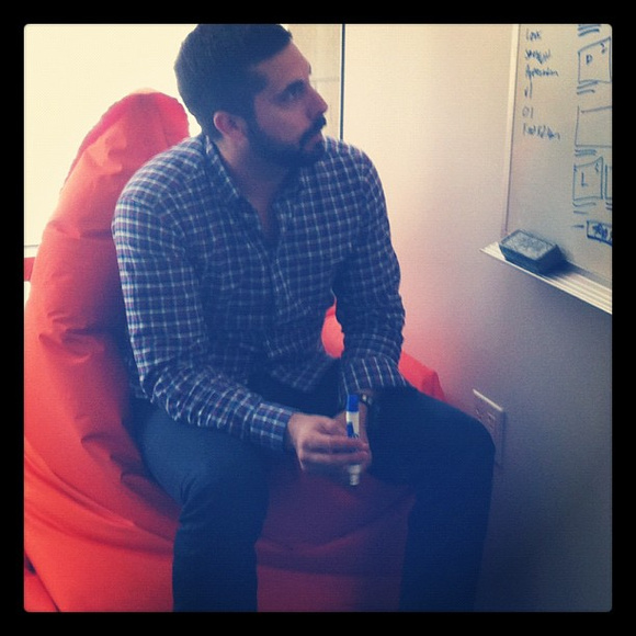 Brandon Gredler, Business Strategist at SpaceCraft, on an orange bean bag chair. Playground Brandon