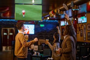happy-football-fans-cheering-drinking-beer-watching-soccer-match.jpg