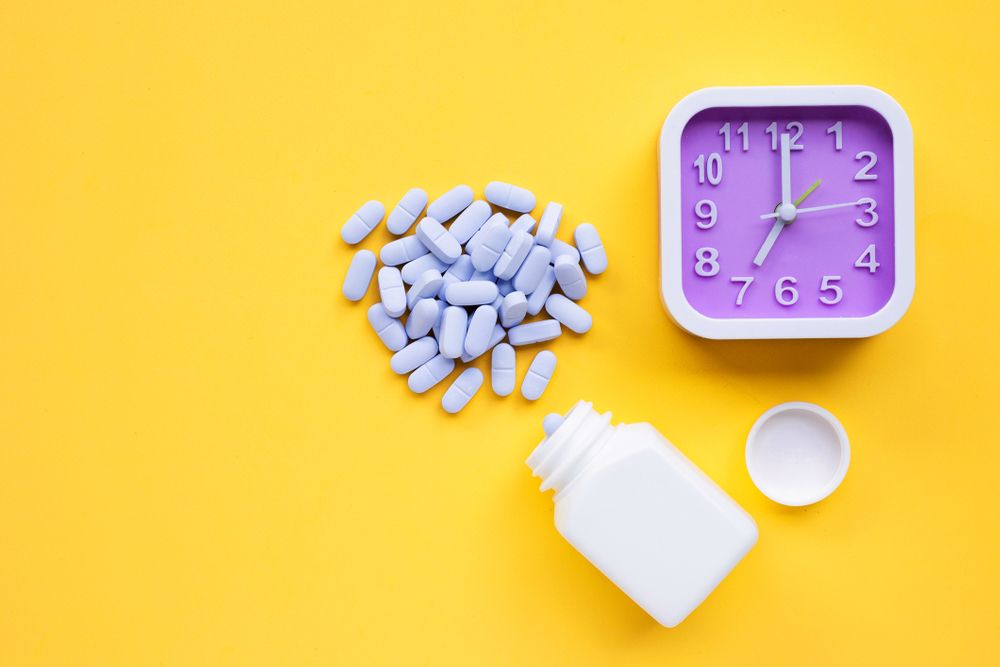 Image of medications on table next to clock Acts Pharmacy and Healthcare Services