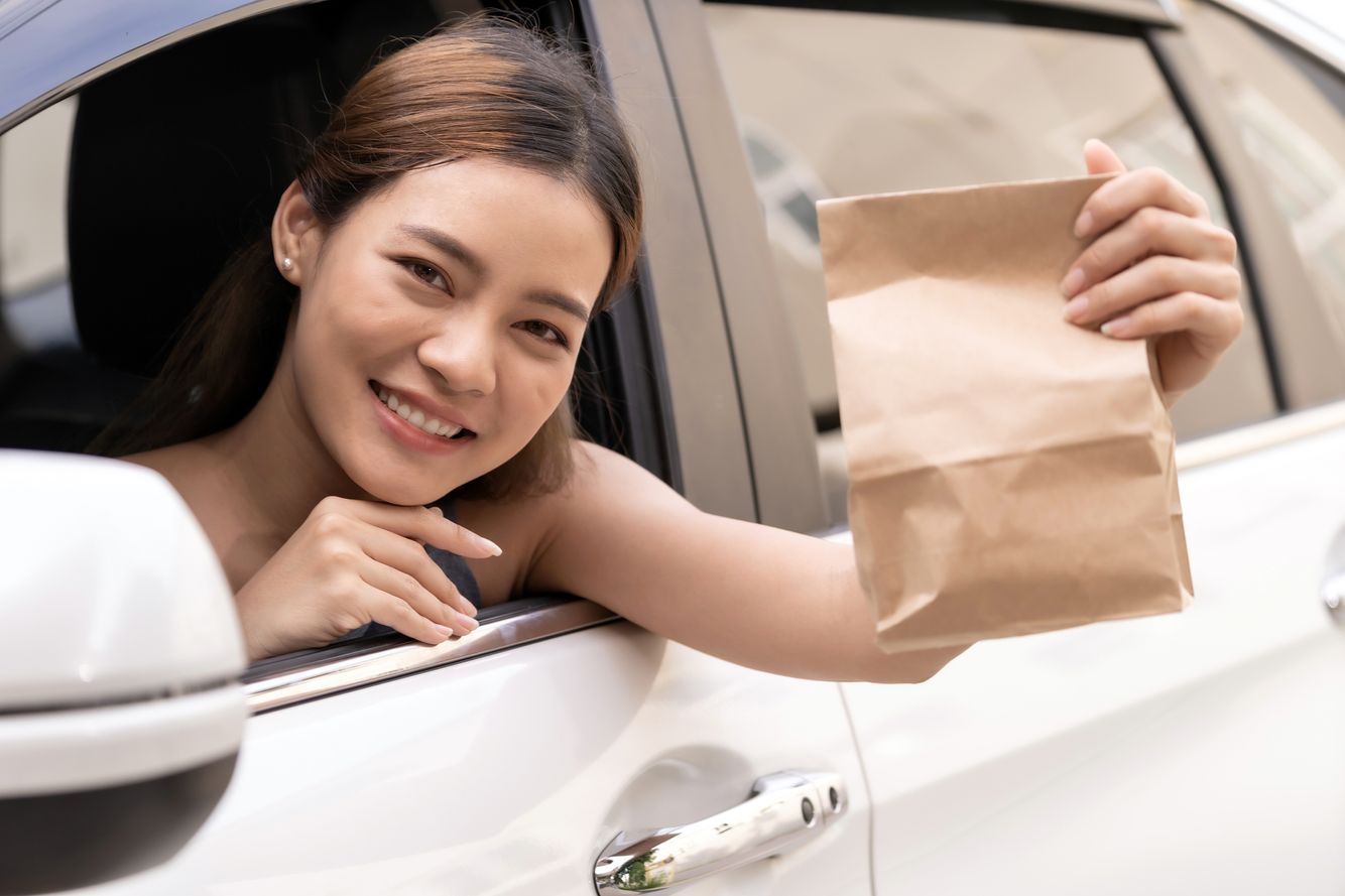 Image of a woman showing a curbside pickup bag Curbside Pickup