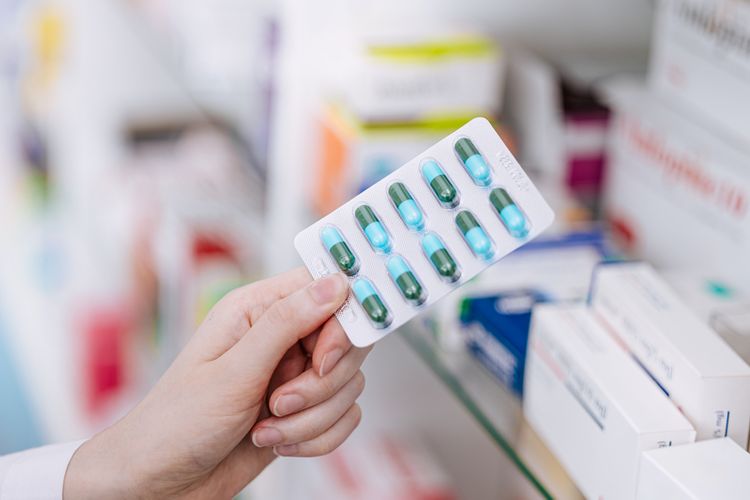 Pharmacist holding pills Medication Therapy Management