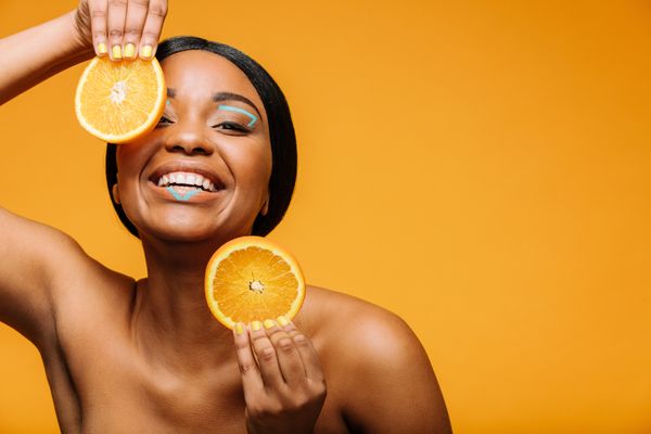 Woman with healthy skin holding oranges Dermatology Compounding