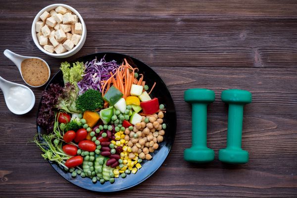 A plate of healthy food next to a set of dumbbells Diabetes education