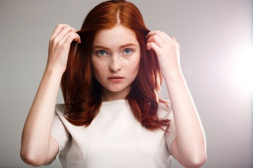 young-beautiful-ginger-girl-gray-wall-with-back-light-min.jpg