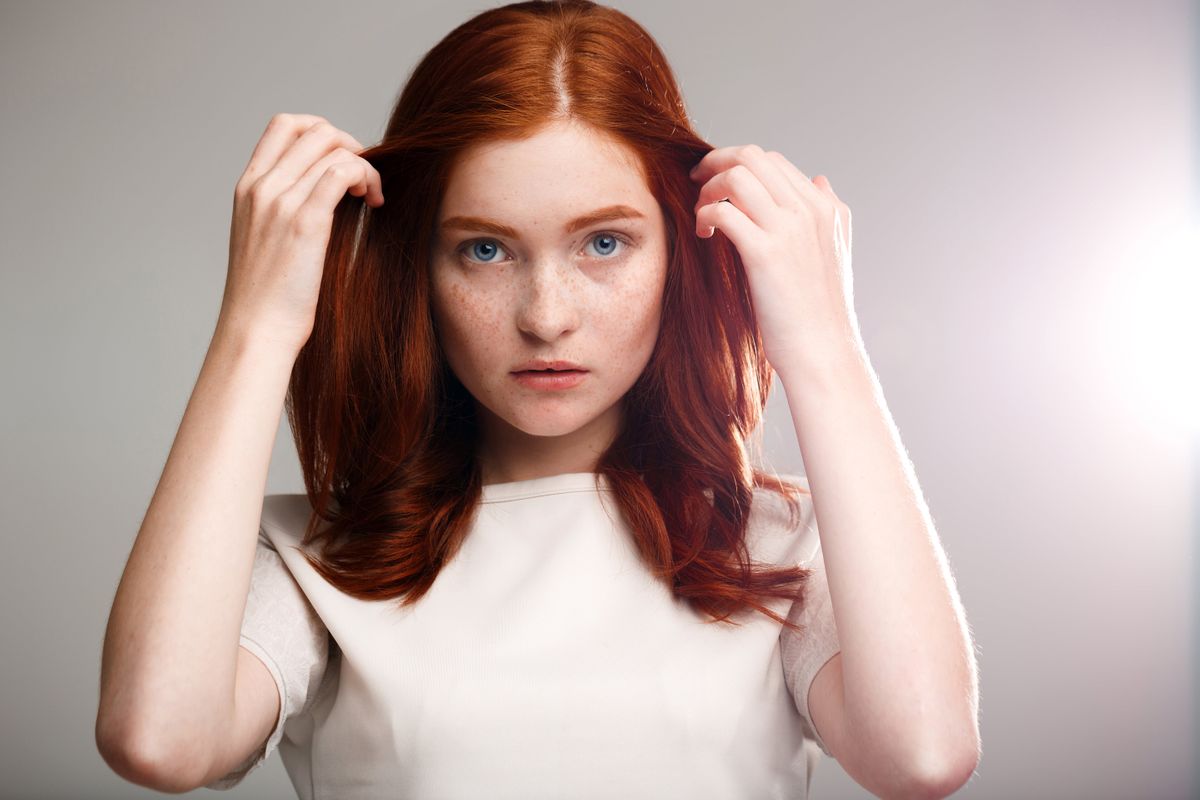 young-beautiful-ginger-girl-gray-wall-with-back-light-min.jpg