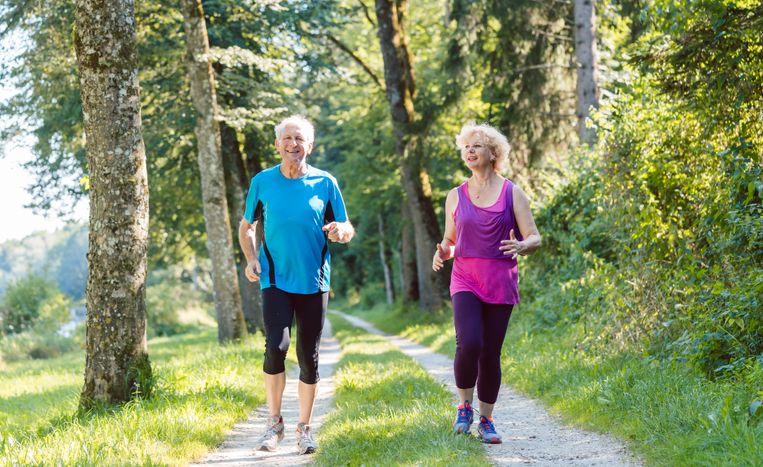 An elderly couple jog on a trail Health and wellness