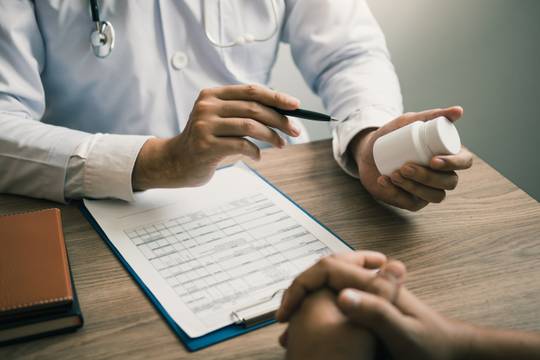 Pharmacist holding pills describing medication