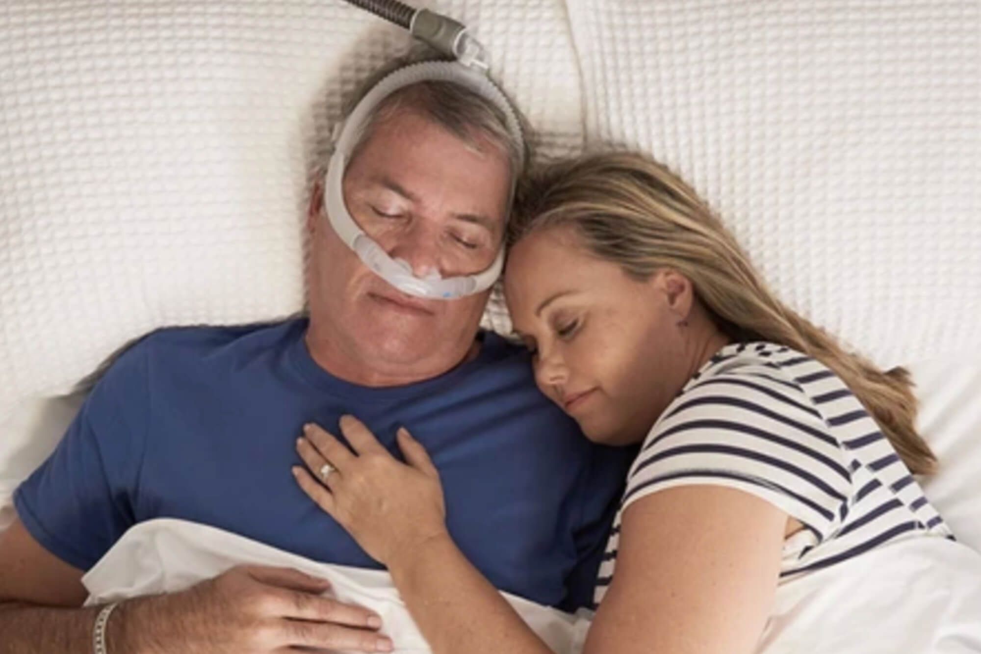 Couple sleeping with a CPAP machine