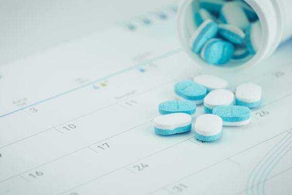 Image of pill spilled on calendar Medication Synchronization