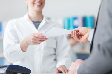 Image of a pharmacist giving a prescription to a customer Medication Services