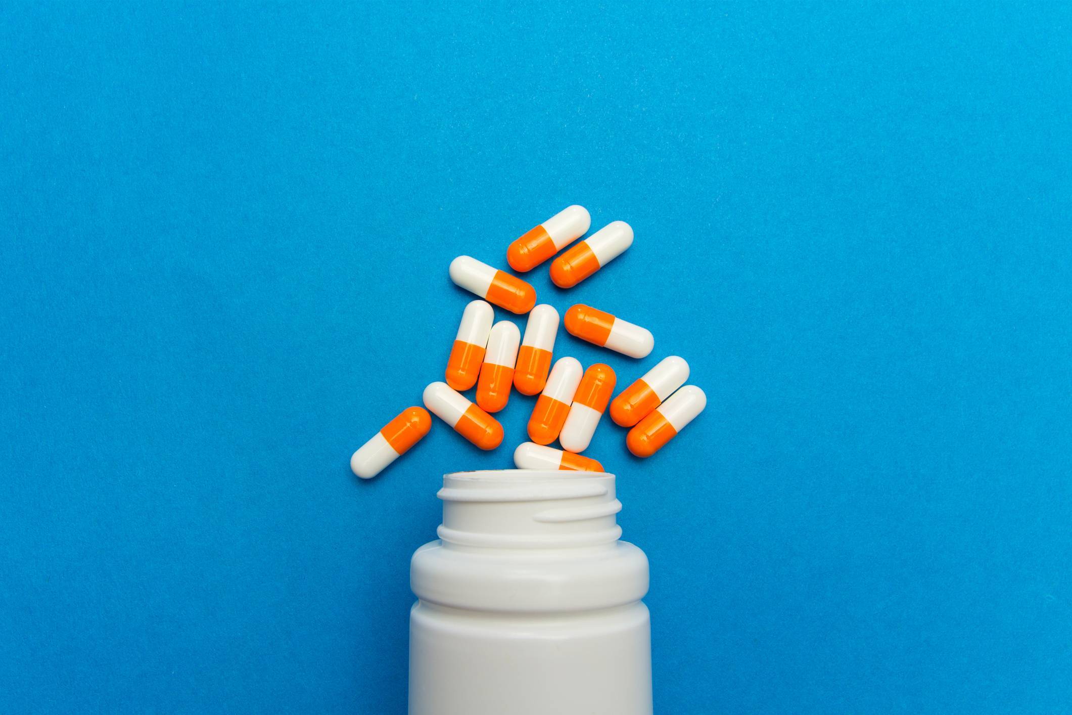 Image of medications spilled on blue background Medication Adherence