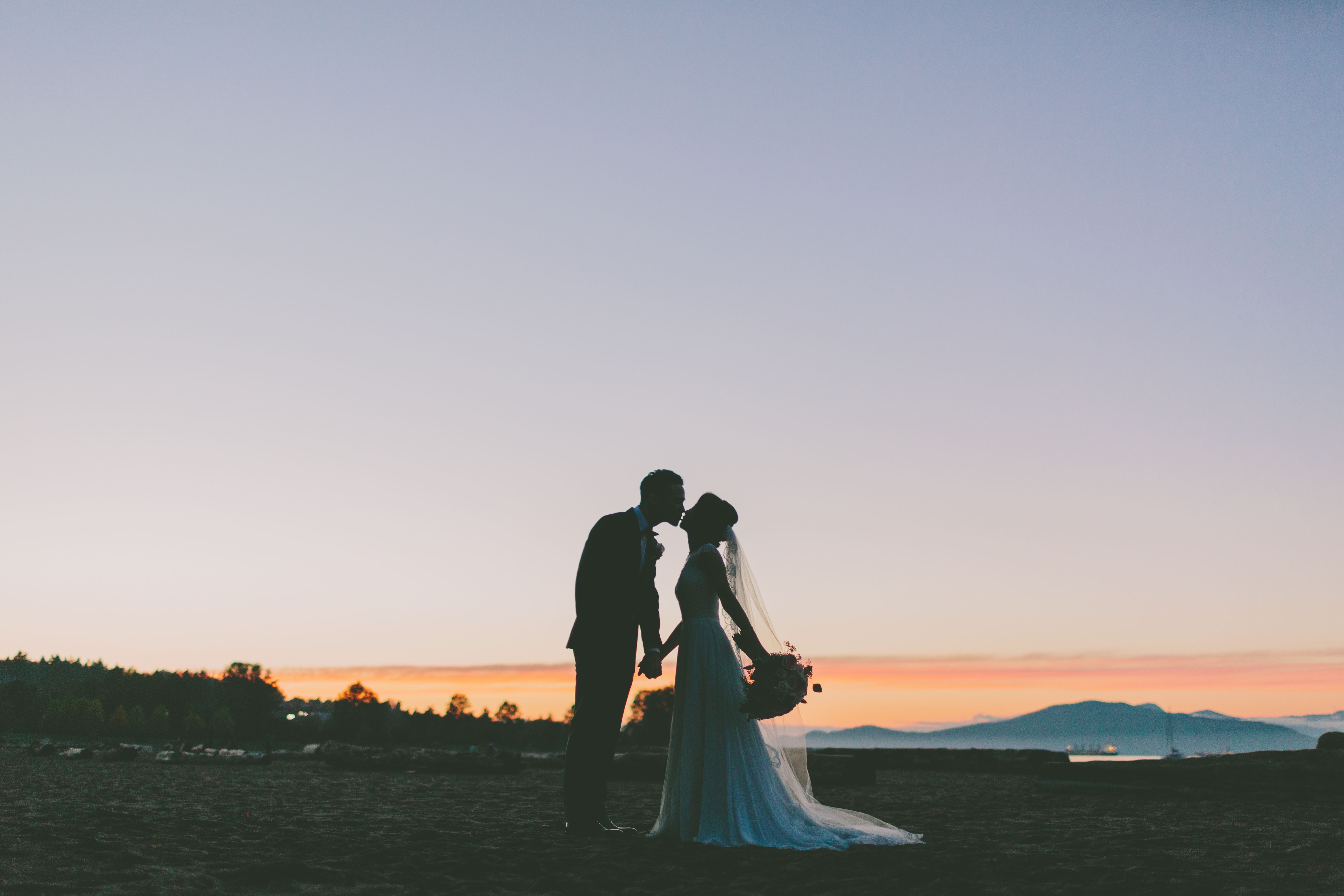 a-silhouette-of-a-bride-and-groom-kissing-on-the-b-Z8SMMW2.jpg