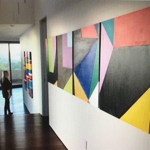 Racae Meyer - 29 Deborah looking at Color Stripes in hallway with light shining on paintings.jpg
