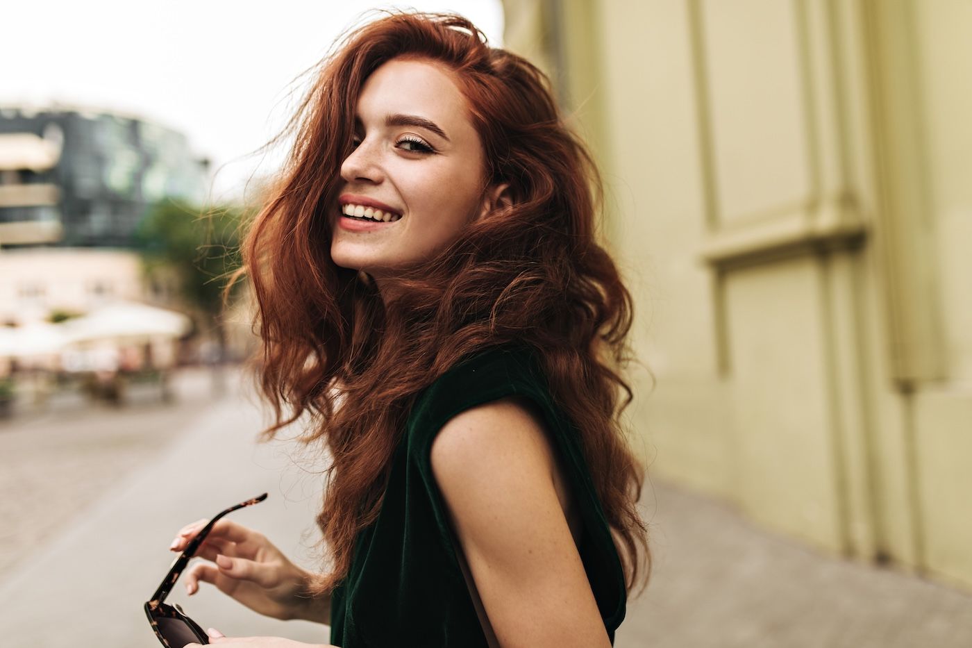 attractive-woman-dark-green-outfit-smiling-outside.jpg