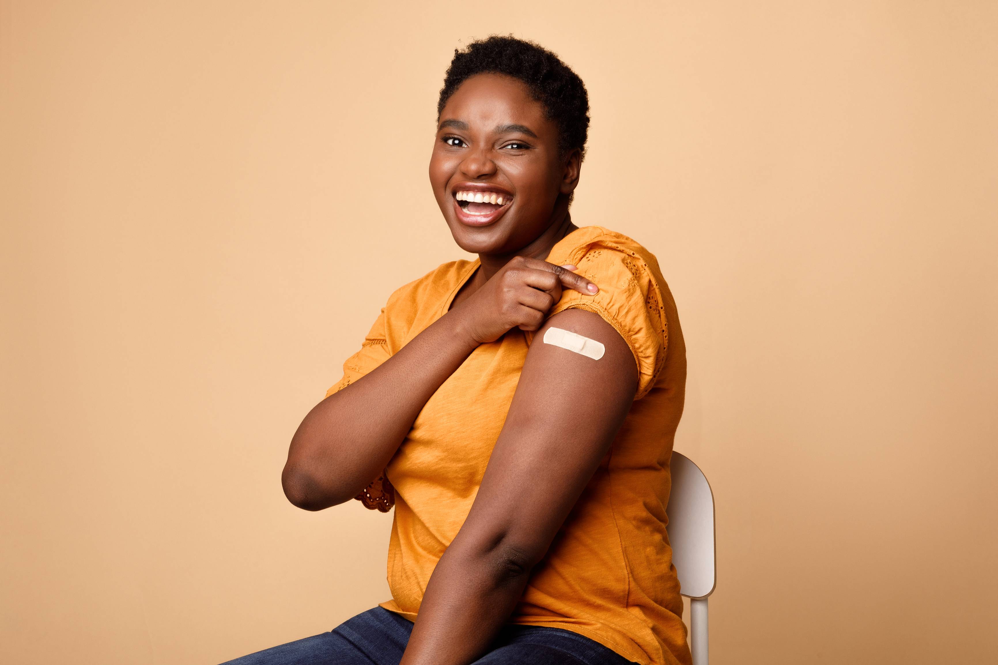 Woman with a bandaid on her upper arm Vaccines