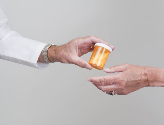 a pharmacist hands a patient their prescription