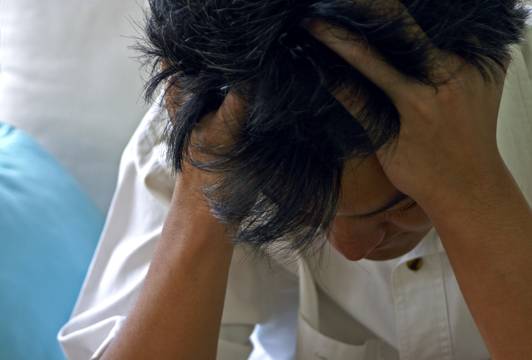 Man holding his head due to a headache Migraines
