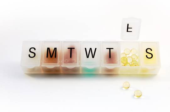 Pill organizer with pills inside. Medication Adherence