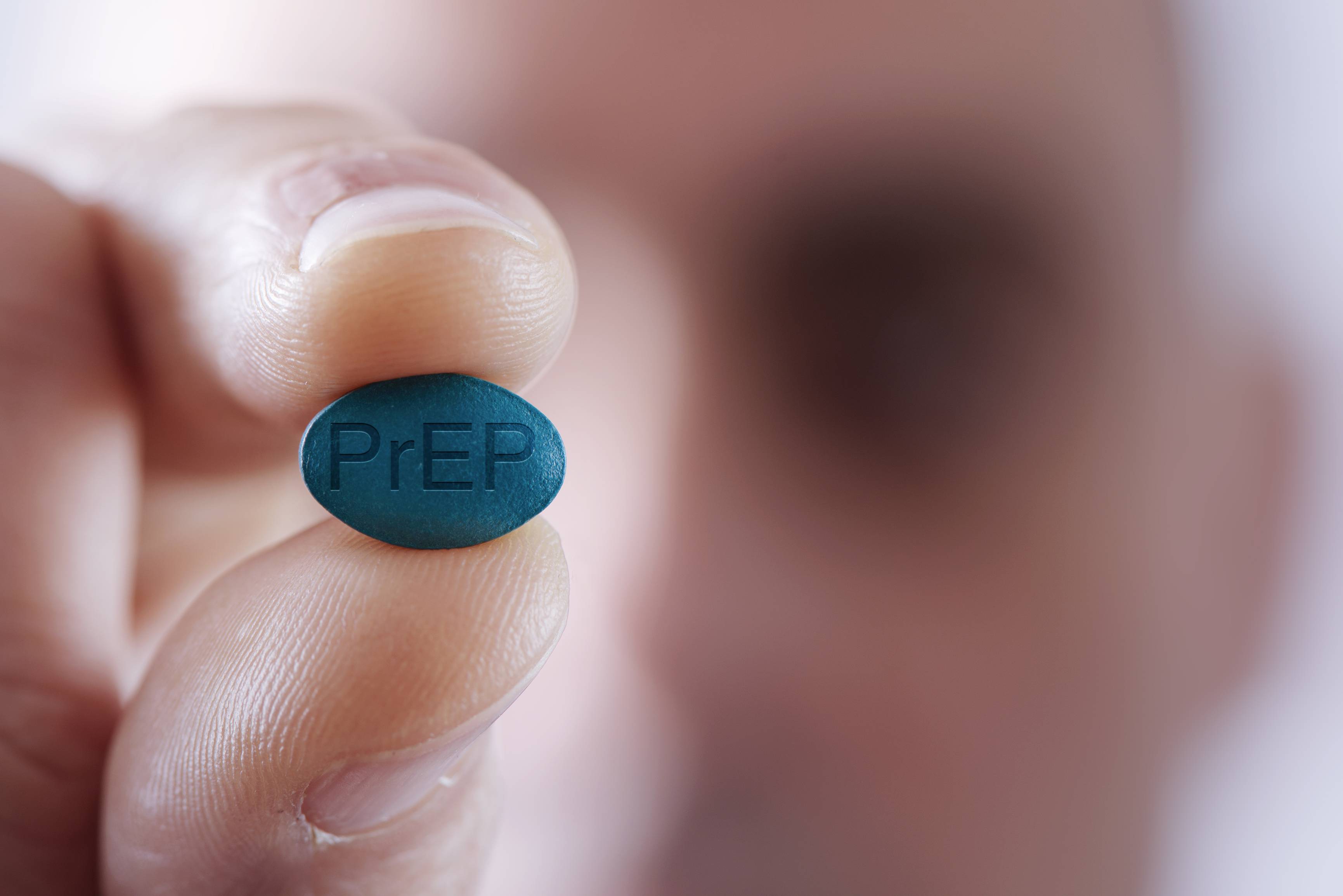 Image of a person holding up a PrEP pill. PrEP Focus Care