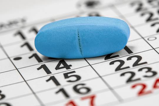 Pill sitting on top of a calendar. Med Sync