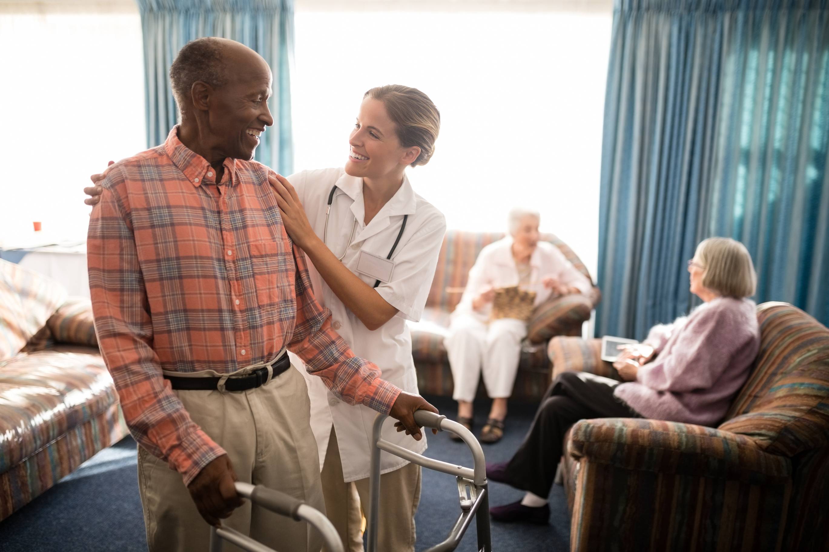 A man being helped by a medical professional in a nursing home LTC