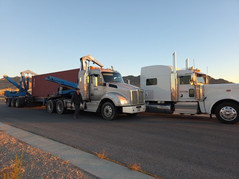sideloader truck transferring container onto another truck's chassis