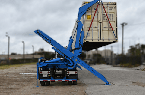 blue sideloader lifting shipping container